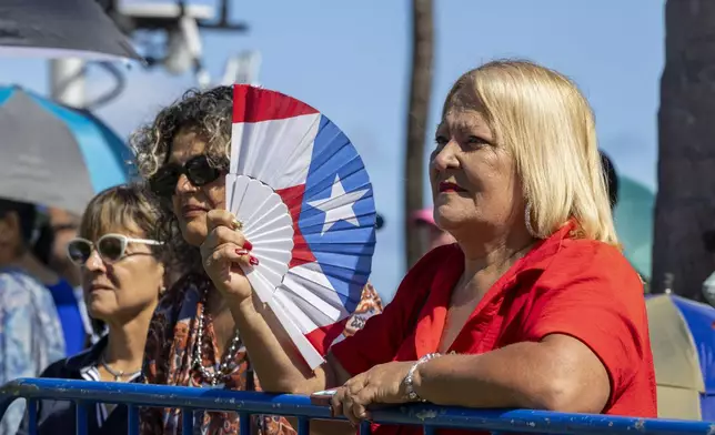 People listen to new Governor Jenniffer Gonzalez Colon speak after she was sworn-in as governor outside the Capitol in San Juan, Puerto Rico, Thursday, Jan. 2, 2025. (AP Photo/Alejandro Granadillo)