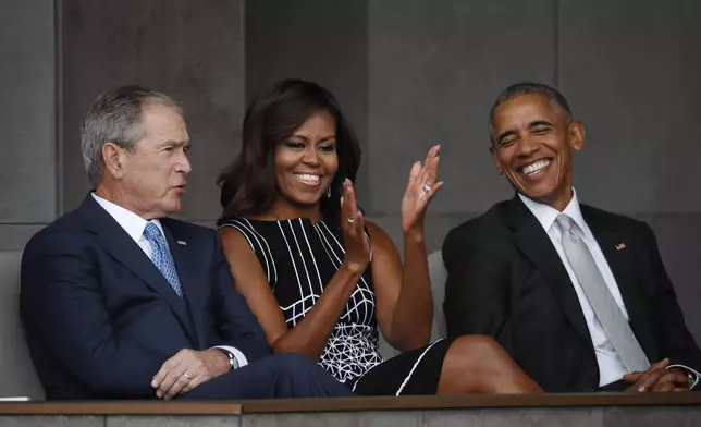 FILE - Former President George W. Bush, left, sits with President Barack Obama, right, and first lady Michelle Obama, center, at the dedication ceremony for the Smithsonian Museum of African American History and Culture on the National Mall in Washington on Sept. 24, 2016. (AP Photo/Pablo Martinez Monsivais, File)