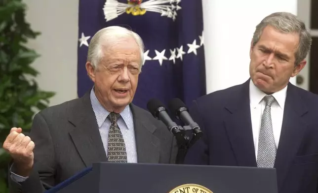 FILE - Former President Jimmy Carter, left, speaks during a Rose Garden ceremony to unveil the report by the National Commission on Federal Election, July 31, 2001, at the White House in Washington as President Bush looks on at right. (AP Photo/Ron Edmonds, File)