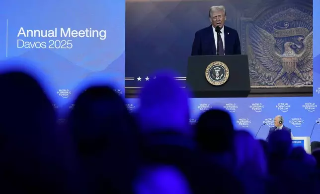 People follow a virtual speech of U.S. president Donald Trump at the Annual Meeting of World Economic Forum in Davos, Switzerland, Thursday, Jan. 23, 2025. (AP Photo/Markus Schreiber)