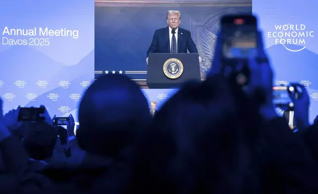 US President Donald J. Trump is shown on screens as he addresses via remote connection a plenary session in the Congress Hall, during the 55th annual meeting of the World Economic Forum (WEF), in Davos, Switzerland, Thursday, Jan. 23, 2025. (Michael Buholzer/Keystone via AP)