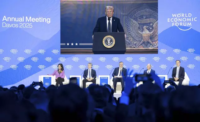 US President Donald J. Trump is shown on screens as he addresses via remote connection a plenary session in the Congress Hall, during the 55th annual meeting of the World Economic Forum (WEF), in Davos, Switzerland, Thursday, Jan. 23, 2025. (Michael Buholzer/Keystone via AP)