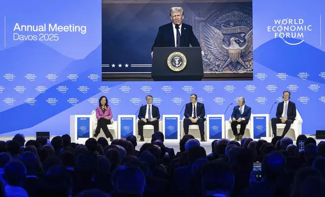 US President Donald J. Trump is shown on screens as he addresses via remote connection a plenary session in the Congress Hall, during the 55th annual meeting of the World Economic Forum (WEF), in Davos, Switzerland, Thursday, Jan. 23, 2025. (Michael Buholzer/Keystone via AP)