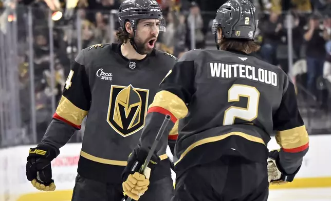 Vegas Golden Knights defenseman Nicolas Hague, left, reacts with Zach Whitecloud after scoring against the Philadelphia Flyers during the second period of an NHL hockey game Thursday, Jan. 2, 2025, in Las Vegas. (AP Photo/David Becker)