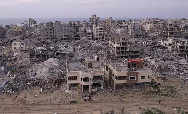 A Palestinian walks past buildings that were destroyed by the Israeli air and ground offensive are seen at the Tel al-Hawa neighbourhood in Gaza Strip, Tuesday, Jan. 28, 2025. (AP Photo/Mohamamd Abu Samra)