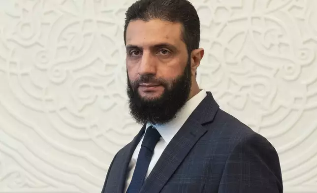 FILE - Syria's de facto leader Ahmad al-Sharaa, formerly known as Abu Mohammed al-Golani, walks in the presidential palace ahead of his meeting with Walid Ellafi, Libyan minister of state for communication and political affairs, in Damascus, Dec. 28, 2024. (AP Photo/Mosa'ab Elshamy, File)