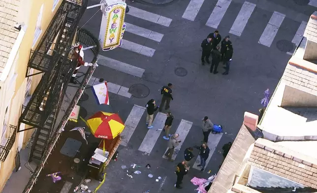 Investigators work the scene after a person drove a vehicle into a crowd killing several, earlier on Canal and Bourbon Street in New Orleans, Wednesday, Jan. 1, 2025. (AP Photo/Gerald Herbert)