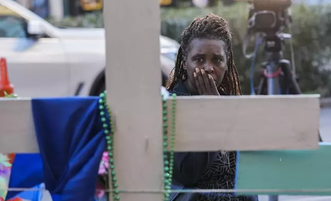 Katriel Faith Gibson, who lives nearby, reacts as she visits a memorial on Canal Street for the victims of a deadly truck attack on New Year's Day in New Orleans, Friday, Jan. 3, 2025. (AP Photo/Gerald Herbert)