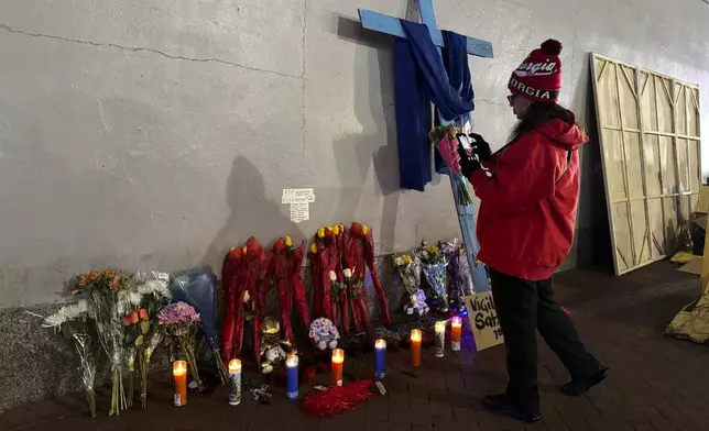 A Georgia football fan takes a photo of a memorial to victims of the deadly truck attack on Bourbon street after the area reopened, Thursday, Jan. 2, 2025, in New Orleans. (AP Photo/Jack Brook)