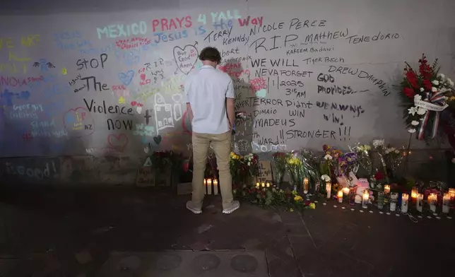 A friend of Kareem Badawi, a victim of the deadly truck attack on New Year's Day in New Orleans, pauses at a memorial for victims after attending his funeral, Friday, Jan. 3, 2025. (AP Photo/Gerald Herbert)