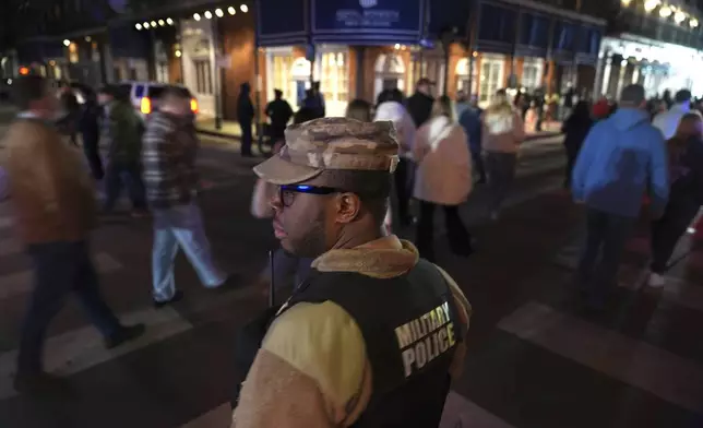 Spc. Nelson Harrison, of the Louisiana National Guard, keeps a watchful eye on Bourbon Street in the French Quarter, Thursday, Jan. 2, 2025 in New Orleans. (AP Photo/George Walker IV)