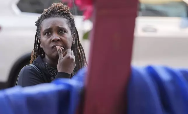 Katriel Faith Gibson, who lives nearby, reacts as she visits a memorial on Canal Street for the victims of a deadly truck attack on New Year's Day in New Orleans, Friday, Jan. 3, 2025. (AP Photo/Gerald Herbert)