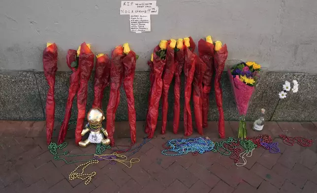 A memorial of flowers is set up on Canal and Bourbon Street, Thursday, Jan. 2, 2025 in New Orleans. (AP Photo/George Walker IV)