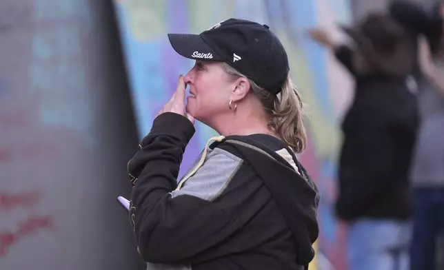 Alisa Kuhns, visiting from Santa Rosa, Calif. reacts at memorial on Bourbon Street for the victims of a deadly truck attack on New Year's Day in New Orleans, Friday, Jan. 3, 2025. (AP Photo/Gerald Herbert)