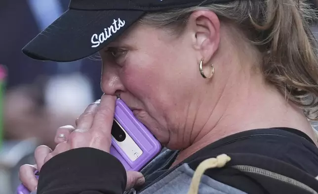 Alisa Kuhns, visiting from Santa Rosa, Calif. reacts at memorial on Bourbon Street for the victims of a deadly truck attack on New Year's Day in New Orleans, Friday, Jan. 3, 2025. (AP Photo/Gerald Herbert)