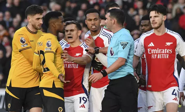 Players argue with referee Michael Oliver after he sent off Arsenal's Myles Lewis-Skelli during the English Premier League soccer match between Wolverhampton Wanderers and Arsenal at the Molineux Stadium in Wolverhampton, England, Saturday, Jan. 25, 2025. (AP Photo/Rui Vieira)