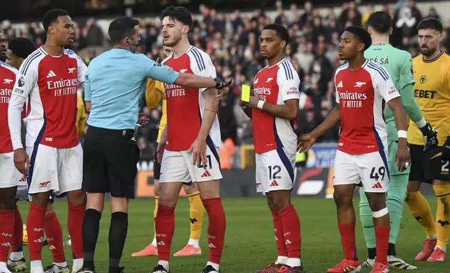 Players argue with referee Michael Oliver after he sent off Arsenal's Myles Lewis-Skelli, right, during the English Premier League soccer match between Wolverhampton Wanderers and Arsenal at the Molineux Stadium in Wolverhampton, England, Saturday, Jan. 25, 2025. (AP Photo/Rui Vieira)