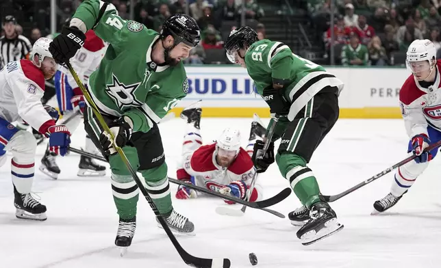 Dallas Stars left wing Jamie Benn (14) takes control of the puck during a penalty kill as Montreal Canadiens' Mike Matheson (8), Jake Evans (71) and Wyatt Johnston (53) look on in the first period of an NHL hockey game in Dallas, Thursday, Jan. 16, 2025. (AP Photo/Tony Gutierrez)