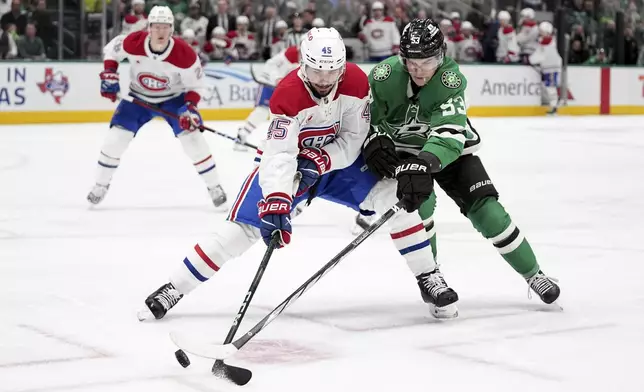 Montreal Canadiens defenseman Alexandre Carrier (45) and Dallas Stars center Wyatt Johnston (53) compete for the puck in the first period of an NHL hockey game in Dallas, Thursday, Jan. 16, 2025. (AP Photo/Tony Gutierrez)