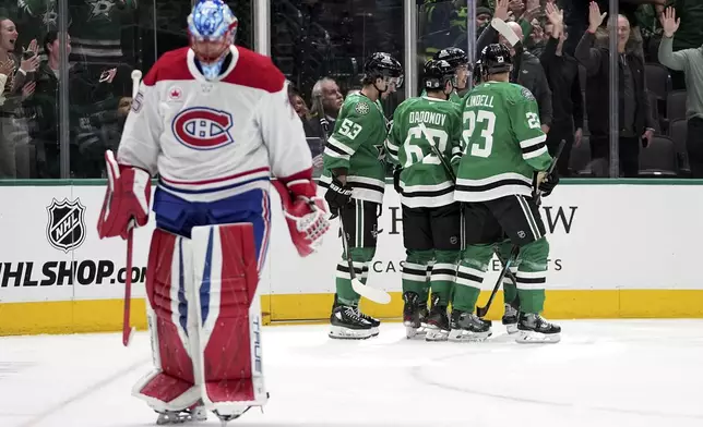 Dallas Stars' Wyatt Johnston (53), Evgenii Dadonov (63) and Esa Lindell (23) celebrate with Jason Robertson, center rear, who scored against Montreal Canadiens goaltender Jakub Dobes, left, in the first period of an NHL hockey game in Dallas, Thursday, Jan. 16, 2025. (AP Photo/Tony Gutierrez)