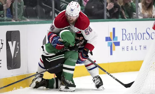 Dallas Stars center Justin Hryckowian, bottom, is held by Montreal Canadiens' David Savard (58) as the two compete for the puck in the first period of an NHL hockey game in Dallas, Thursday, Jan. 16, 2025. (AP Photo/Tony Gutierrez)