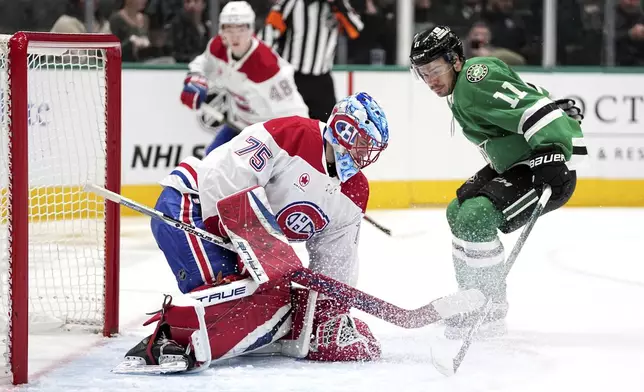 Montreal Canadiens goaltender Jakub Dobes (75) covers up a shot under pressure from Dallas Stars center Logan Stankoven (11) in the first period of an NHL hockey game in Dallas, Thursday, Jan. 16, 2025. (AP Photo/Tony Gutierrez)