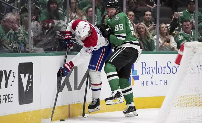Dallas Stars center Matt Duchene (95) slams Montreal Canadiens' Kaiden Guhle (21) against the boards as they compete for the puck in the first period of an NHL hockey game in Dallas, Thursday, Jan. 16, 2025. (AP Photo/Tony Gutierrez)