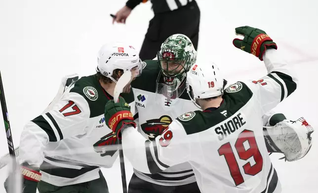 Minnesota Wild goaltender Marc-Andre Fleury, center, celebrates with left wing Marcus Foligno (17) and center Devin Shore (19) after an NHL hockey game against the Washington Capitals, Thursday, Jan. 2, 2025, in Washington. The Wild won 4-3 in a shootout. (AP Photo/Nick Wass)