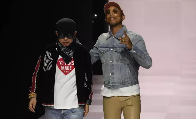 Pharrell Williams, right, walks with with Nigo, artistic designer for Kenzo, with who co-creates a collection, after the men's Louis Vuitton Fall-Winter 2025-2026 collection, that was presented in Paris, Tuesday, Jan. 21, 2025. (AP Photo/Michel Euler)