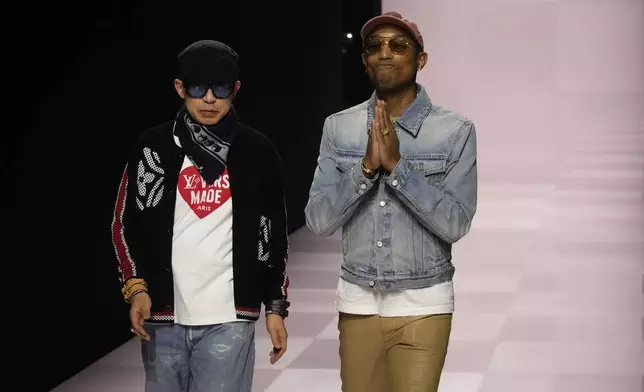 Pharrell Williams, right, walks with with Nigo, artistic designer for Kenzo, with who co-creates a collection, after the men's Louis Vuitton Fall-Winter 2025-2026 collection, that was presented in Paris, Tuesday, Jan. 21, 2025. (AP Photo/Michel Euler)