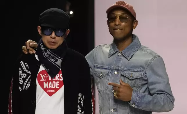 Pharrell Williams, right, walks with with Nigo, artistic designer for Kenzo, with who co-creates a collection, after the men's Louis Vuitton Fall-Winter 2025-2026 collection, that was presented in Paris, Tuesday, Jan. 21, 2025. (AP Photo/Michel Euler)