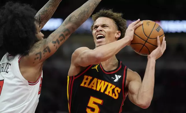 Chicago Bulls guard Coby White (0), left, guards Atlanta Hawks guard Dyson Daniels (5) during the first half of an NBA basketball game Wednesday, Jan. 15, 2025, in Chicago. (AP Photo/Erin Hooley)
