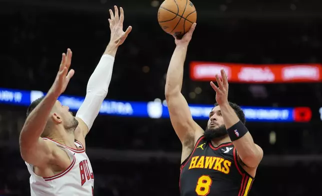 Chicago Bulls center Nikola Vucevic (9), left, tries to block Atlanta Hawks forward David Roddy (8) as he makes a shot during the first half of an NBA basketball game Wednesday, Jan. 15, 2025, in Chicago. (AP Photo/Erin Hooley)