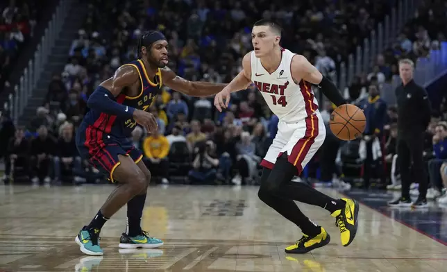 Miami Heat guard Tyler Herro, right, moves the ball while defended by Golden State Warriors guard Buddy Hield during the first half of an NBA basketball game Tuesday, Jan. 7, 2025, in San Francisco. (AP Photo/Godofredo A. Vásquez)