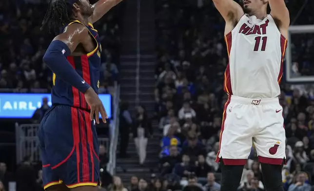 Miami Heat forward Jaime Jaquez Jr., right, shoots a 3-point basket over Golden State Warriors guard Buddy Hield during the first half of an NBA basketball game Tuesday, Jan. 7, 2025, in San Francisco. (AP Photo/Godofredo A. Vásquez)