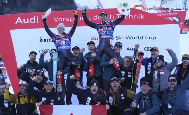 The winner Canada's James Crawford and third placed Canada's Cameron Alexander celebrate with the team after an alpine ski, men's World Cup downhill in Kitzbühel, Austria, Saturday, Jan. 25, 2025. (AP Photo/Giovanni Auletta)