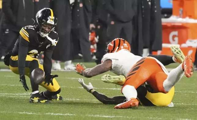 Pittsburgh Steelers cornerback Beanie Bishop Jr., left, intercepts a pass intended for Cincinnati Bengals wide receiver Ja'Marr Chase, top right, that was broken up by Steelers linebacker Patrick Queen, bottom right, during the first half of an NFL football game in Pittsburgh, Saturday, Jan. 4, 2025. (AP Photo/Gene J. Puskar)