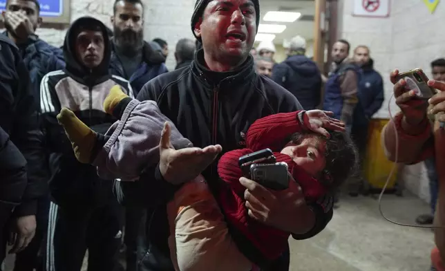 A man reacts while carrying a wounded girl to Al-Aqsa Martyrs Hospital following Israeli army airstrikes in Deir al-Balah, central Gaza Strip, Saturday Jan. 4, 2025.(AP Photo/Abdel Kareem Hana)