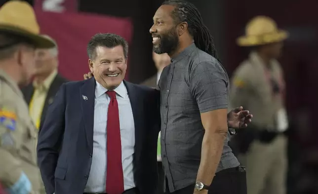 Arizona Cardinals owner Michael Bidwill, left, talks with former Cardinals great Larry Fitzgerald, right, during the second half of an NFL football game against the San Francisco 49ers in Glendale, Ariz., Sunday, Jan. 5, 2025. (AP Photo/Ross D. Franklin)