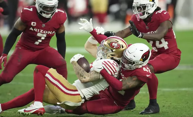 San Francisco 49ers wide receiver Ricky Pearsall (14) is tackled by Arizona Cardinals safety Dadrion Taylor-Demerson (42) during the second half of an NFL football game in Glendale, Ariz., Sunday, Jan. 5, 2025. (AP Photo/Ross D. Franklin)