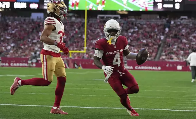 Arizona Cardinals wide receiver Greg Dortch (4) runs into the end zone for a touchdown against San Francisco 49ers cornerback Nick McCloud (35) during the second half of an NFL football game in Glendale, Ariz., Sunday, Jan. 5, 2025. (AP Photo/Rick Scuteri)