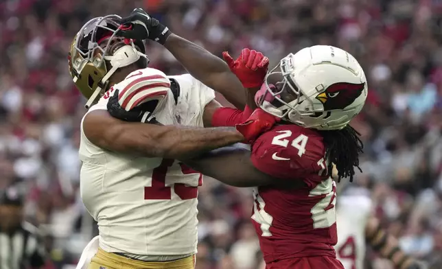 Arizona Cardinals cornerback Starling Thomas V (24) grabs the face mask of San Francisco 49ers wide receiver Jauan Jennings (15) during the first half of an NFL football game in Glendale, Ariz., Sunday, Jan. 5, 2025. (AP Photo/Rick Scuteri)