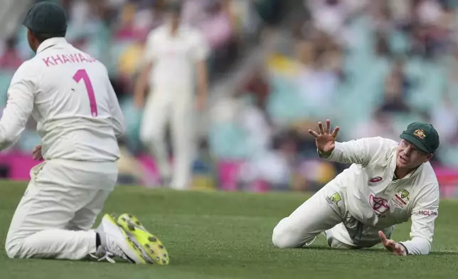 Australia's Steve Smith gestures to teammate Australia's Usman Khawaja after dropping a catch during play on the second day of the fifth cricket test between India and Australia at the Sydney Cricket Ground, in Sydney, Australia, Saturday, Jan. 4, 2025. (AP Photo/Mark Baker)