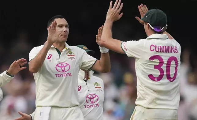 Australia's captain Pat Cummins, right, and Scot Boland celebrate the wicket of India's Nitish Kumar Reddy during play on the second day of the fifth cricket test between India and Australia at the Sydney Cricket Ground, in Sydney, Australia, Saturday, Jan. 4, 2025. (AP Photo/Mark Baker)