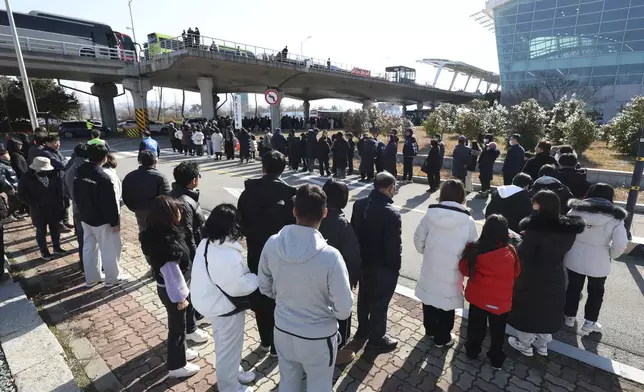 Mourners wait to pay tribute to the victims of a plane fire at a memorial altar at Muan International Airport in Muan, South Korea, Wednesday, Jan. 1, 2025. (Kim Sun-woong/Newsis via AP)