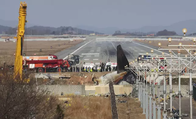 Relatives of passengers on a plane which skidded off a runway and burst into flames, are seen near the site of a plane crash at Muan International Airport in Muan, South Korea, Wednesday, Jan. 1, 2025. (Lee Jin-wook/Yonhap via AP)