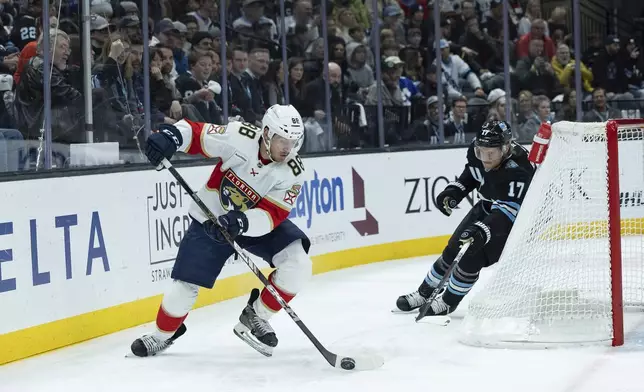 Florida Panthers defenseman Nate Schmidt (88) moves the puck against Utah Hockey Club center Nick Bjugstad (17) during the first period of an NHL hockey game, Wednesday, Jan. 8, 2025, in Salt Lake City. (AP Photo/Melissa Majchrzak)