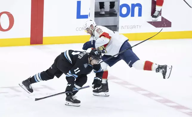 Utah Hockey Club right wing Dylan Guenther (11) gets tangled up with Florida Panthers center Aleksander Barkov (16) during the third period of an NHL hockey game, Wednesday, Jan. 8, 2025, in Salt Lake City. (AP Photo/Melissa Majchrzak)