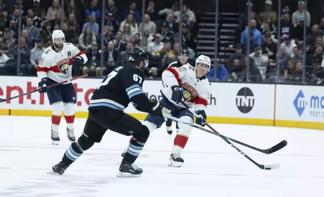 Florida Panthers defenseman Gustav Forsling (42) moves the puck against Utah Hockey Club left wing Lawson Crouse (67) during the second period of an NHL hockey game, Wednesday, Jan. 8, 2025, in Salt Lake City. (AP Photo/Melissa Majchrzak)