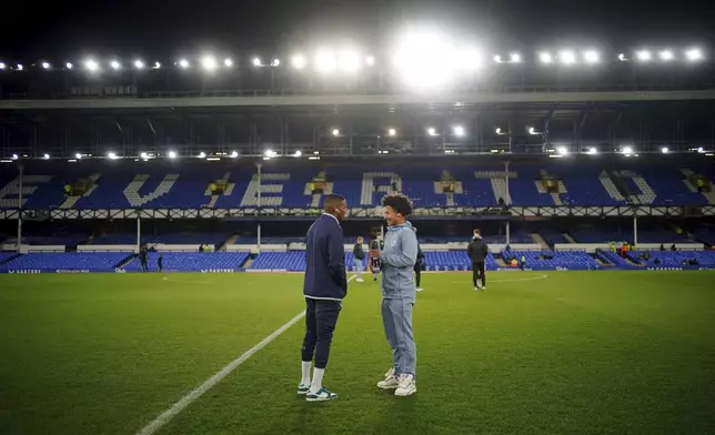 Everton's Ashley Young, left, speaks with his son, Peterborough United's Tyler Young, before the Emirates FA Cup third round match at Goodison Park, Liverpool, England, Thursday Jan. 9, 2025. (Peter Byrne/PA via AP)